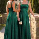 Pilar Verde Escuro | Vestido comprido evasê em cetim brilhante com bolsos